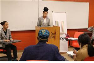 Student Kennedy Barlow speaking in front of listeners